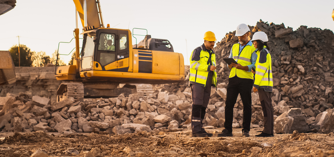 group of construction workers looking at tablet on construction site